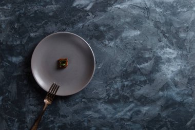 Beton zeminde bir tabakta çavdar ekmeği kırıntısı. Restoran yemeği konsepti, çok paraya küçük bir porsiyon..