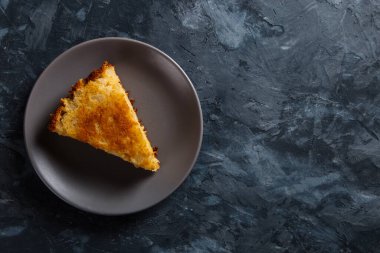 Bir parça elmalı turta gri bir tabakta, beton zemine karşı..