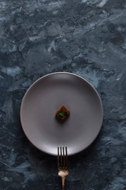 Beton zeminde bir tabakta çavdar ekmeği kırıntısı. Restoran yemeği konsepti, çok paraya küçük bir porsiyon..