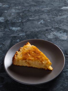 Bir parça elmalı turta gri bir tabakta, beton zemine karşı..