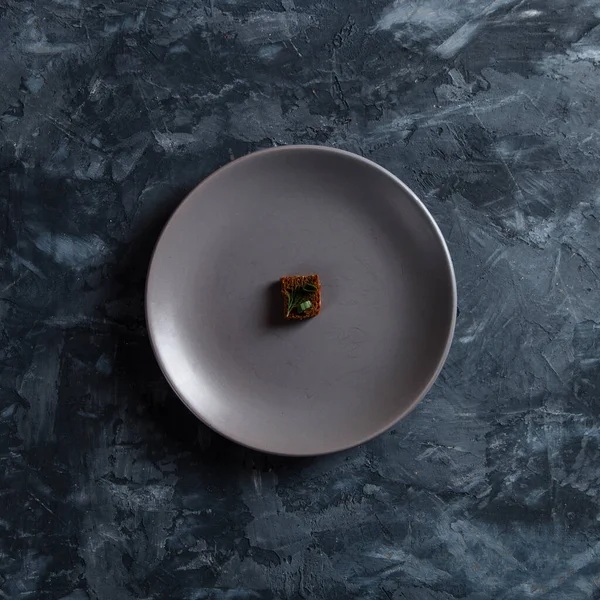 Beton zeminde bir tabakta çavdar ekmeği kırıntısı. Restoran yemeği konsepti, çok paraya küçük bir porsiyon..