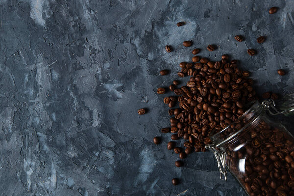 Coffee crumbled from a jar, on a dark concrete background.