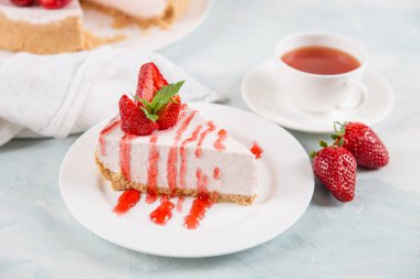 Tatlı kahvaltı, çay ve taze çilek ve nane ile nefis peynirli kek, pişirilmemiş ev yapımı tarif, mavi bir taş masanın üzerinde. Boşluğu kopyala.