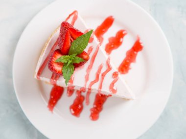 Tatlı kahvaltı, taze çilek ve nane ile nefis cheesecake, pişirilmemiş ev yapımı tarif, mavi taş masada. Boşluğu kopyala.