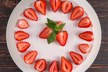 Taze çilek ve nane ile nefis cheesecake, ahşap bir masada pişirmeden ev yapımı tarifi.