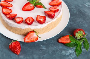 Tatlı kahvaltı, taze çilek ve nane ile nefis cheesecake, pişirilmemiş ev yapımı tarif, koyu mavi taş masada. Boşluğu kopyala.