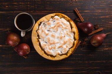 Kremalı armut turtası, ahşap masada ev yapımı hamur işleri, kahve ve baharatlar. Boşluğu kopyala.