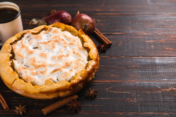 Kremalı armut turtası, ahşap masada ev yapımı hamur işleri, kahve ve baharatlar. Boşluğu kopyala.