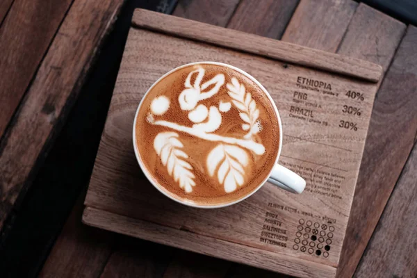 Sıcak kahve cappuccino latte sanat üstten görünüm ahşap tablo.