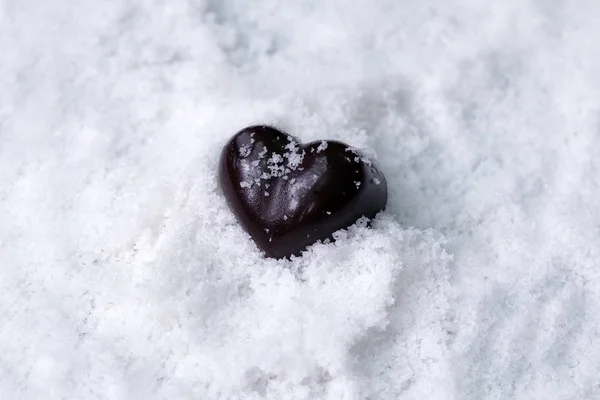 Süt ve koyu çikolata kalp kopya alanı, siyah Sevgililer günü kavramı ile kar üzerinde muhtelif.