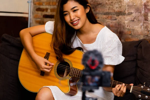 Азиатка играет на гитаре для vlog — стоковое фото
