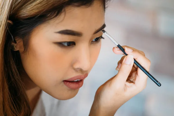 Asiático mulher pintura sobrancelha — Fotografia de Stock