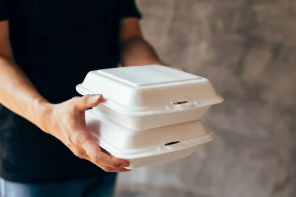 Primer plano del repartidor que entrega una holgura de la caja del almuerzo de la espuma —  Fotos de Stock