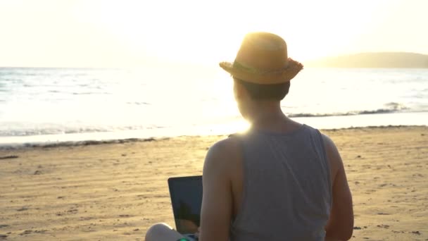 若い男性ビジネスマンは、熱帯の夏のビーチで成功のために手を上げて-それは、金融の自由や遠隔作業の概念などの自由を示しています — ストック動画