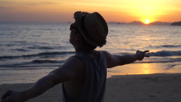 Silhouette back of young male travel backpacker doing peace v sign finger against sunset and tropical summer ocean beach background — Stock Video