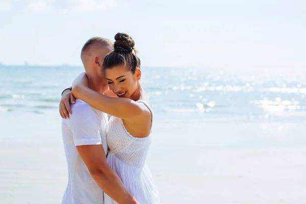 Gelukkige vrouw knuffelen haar vriendje op het strand — Stockfoto