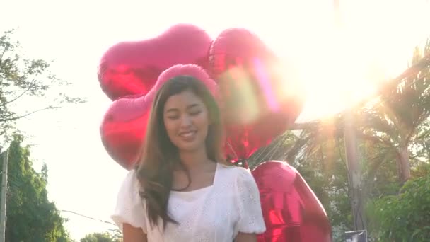 Sinnliche asiatische Frau mit Luftballons im Park — Stockvideo