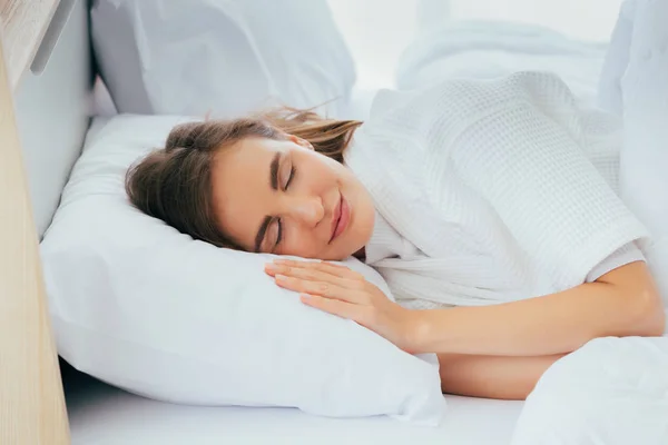 Smiling woman sleeping on bed — Stock Photo, Image