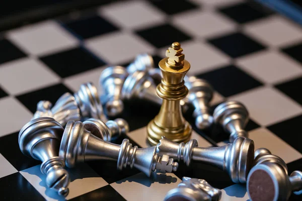 Perdeu peças de xadrez de prata em torno de rei dourado — Fotografia de Stock