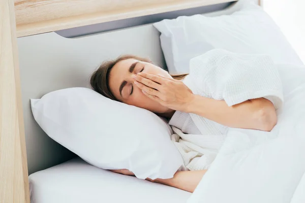 Sleepy woman yawning in bed — Stock Photo, Image