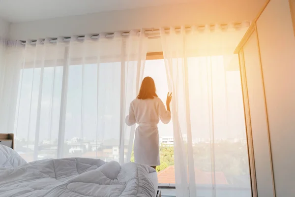 Woman looking out window in morning — Stock Photo, Image