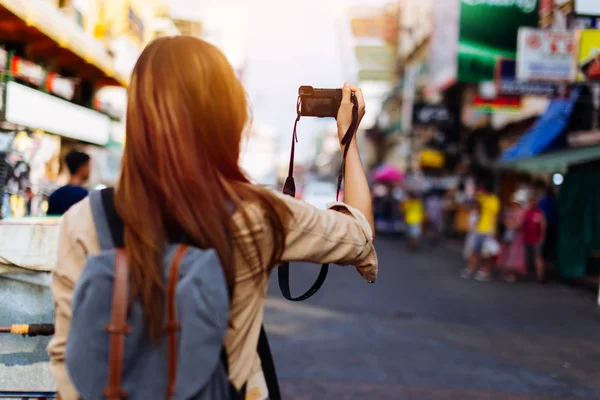 Young woman holding a camera and taking photos in Thailand — Stock Photo, Image