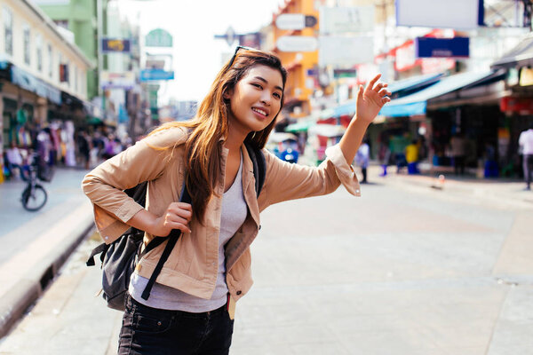 Young woman calling a cab in the city