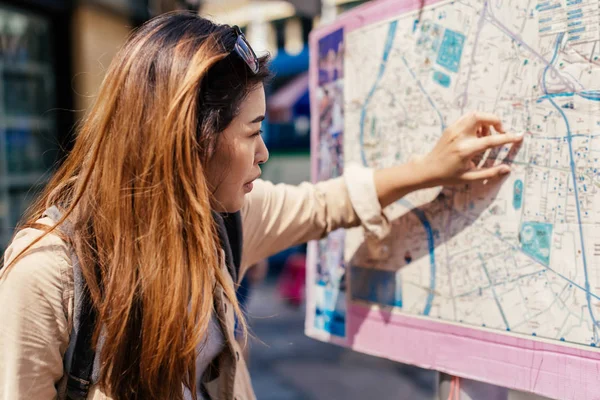 Touristin schaut auf Stadtplan und verliert sich — Stockfoto