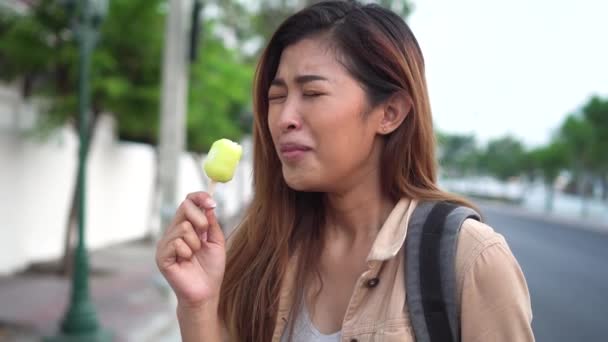 Young woman showing thumbs up with popsicle ice cream in outdoor scene — Stock Video