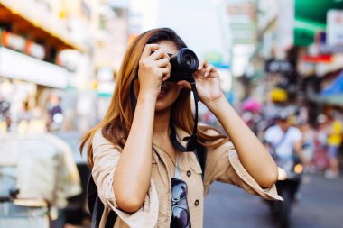 Genç kadın bir kamera tutarak ve Tayland fotoğraf çekmek