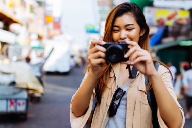 Genç kadın bir kamera tutarak ve Tayland fotoğraf çekmek