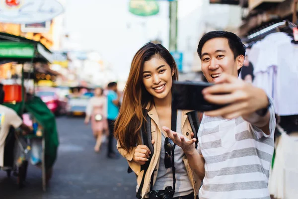 旅行中に自分撮りを取るカジュアルなアジアのカップル — ストック写真