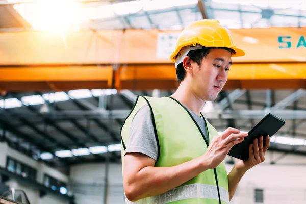 Young Asian male factory worker using a digital tablet — Stock Photo, Image