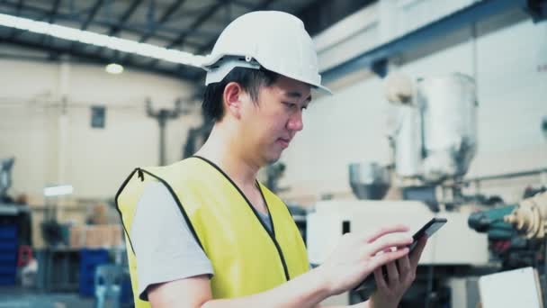 Jonge Aziatische mannelijke fabriekswerker met behulp van een digitale tablet — Stockvideo