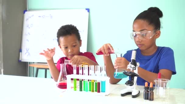 Dos niños afroamericanos mezclados probando experimentos de laboratorio de química — Vídeos de Stock