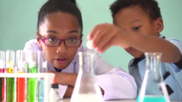 Two African American mixed kids testing chemistry lab experiment — Stock Video