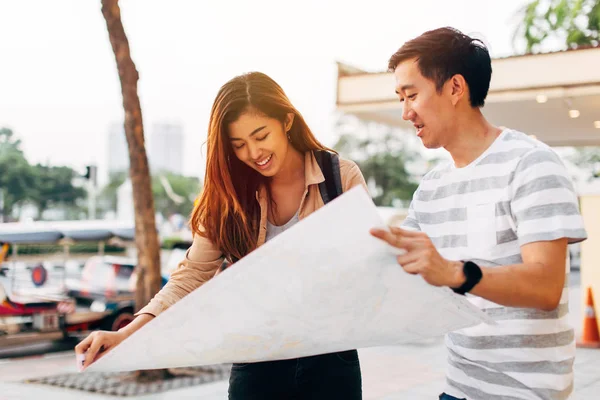Young Asian couple with map on street — ストック写真