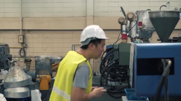 Молодий промисловий інженер, що йде всередину заводу і перевіряє на виробничих машинах — стокове відео