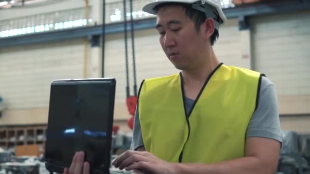 공장에서 노트북으로 작업하는 하드 햇을 가진 산업 엔지니어 — 비디오
