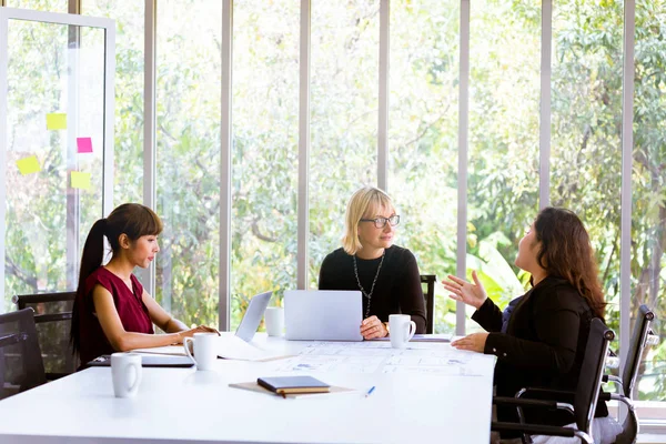 Obchodní ženy diskutují u stolu v kanceláři — Stock fotografie