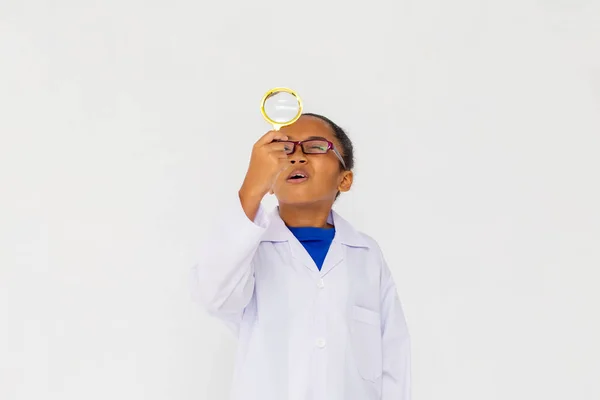 Jong tiener Afro-Amerikaans kind dragen lab jas opkijken met vergrootglas — Stockfoto