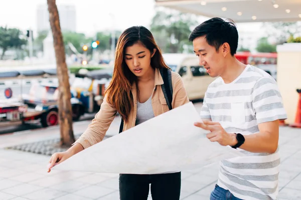 Unga asiatiska par med karta på gatan — Stockfoto