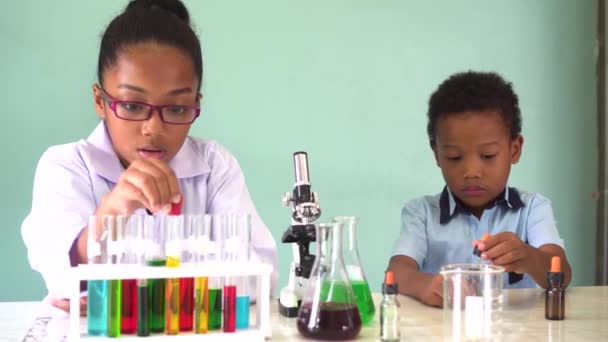 Two African American mixed kids testing chemistry lab experiment — Stock Video