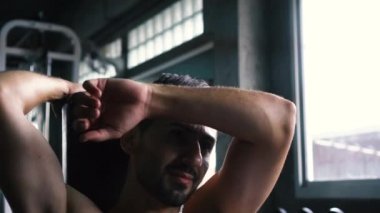 Spor salonunda alnından ter silen genç adam.