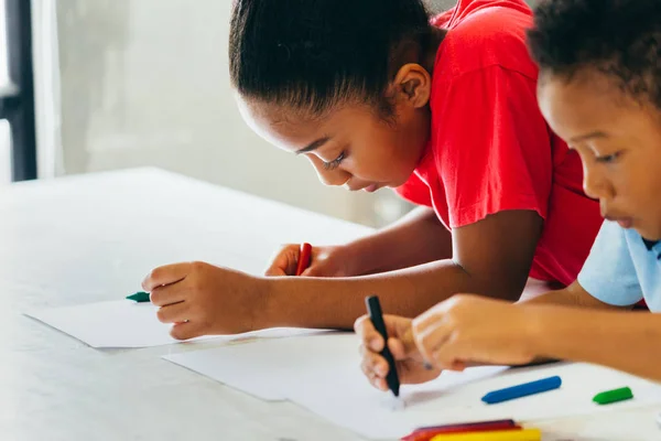 African American dzieci uczą się rysować z kredą na stole — Zdjęcie stockowe