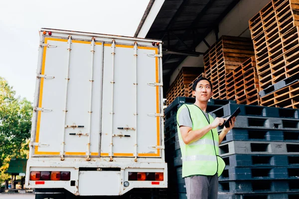 Young Asian male logistics warehouse distribution business entrepreneur using a digital tablet — Stock Photo, Image