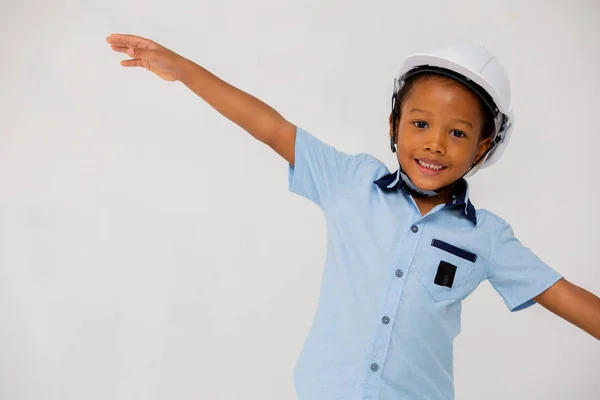 Menino pré-escolar afro-americano usando capacete de chapéu duro estendendo os braços — Fotografia de Stock