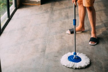 Adam paspas aracı kullanarak oturma odası Temizleme