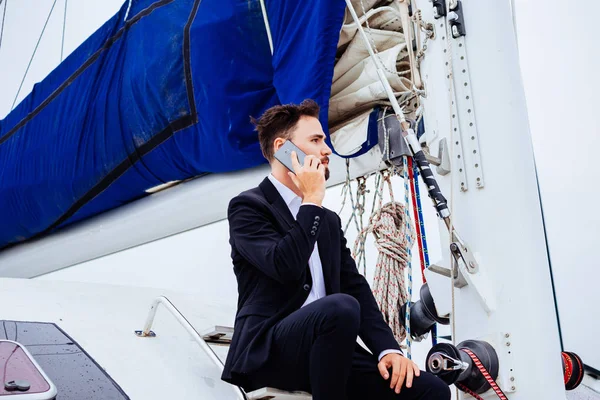 Man talking on phone sitting on yacht