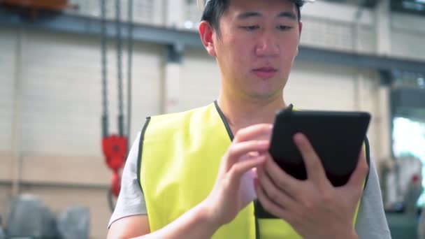 Jeune asiatique mâle ouvrier d'usine à l'aide d'une tablette numérique — Video